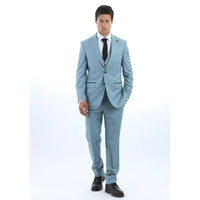 Vyras, vilkintis šviesiai mėlyną kostiumą, baltus marškinius ir juodą kaklaraištį baltame fone