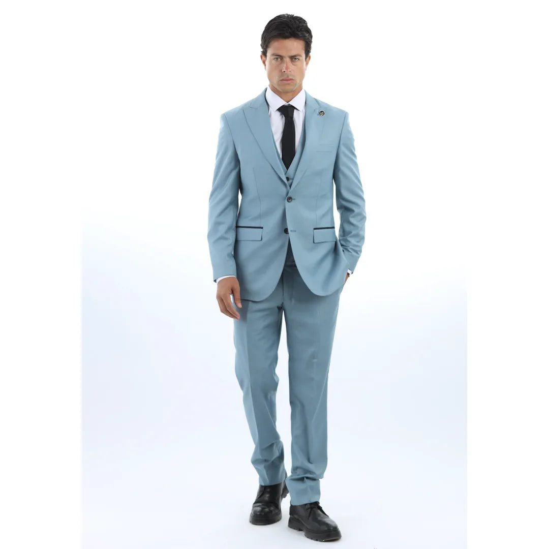 Vyras, vilkintis šviesiai mėlyną kostiumą, baltus marškinius ir juodą kaklaraištį baltame fone